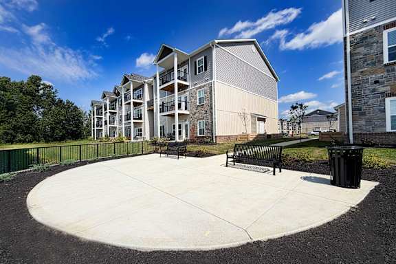 A modern apartment complex with a circular courtyard in the foreground.