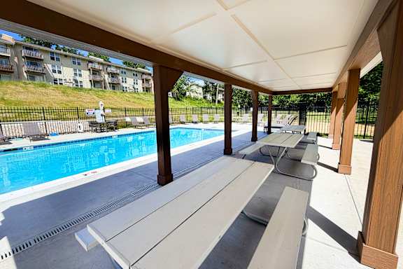 A pool area with a bench and a pool.
