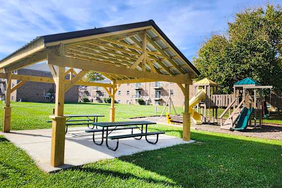 a picnic area with a picnic table and a playground at Crown Crossing Apartments, Amelia, OH, 45102