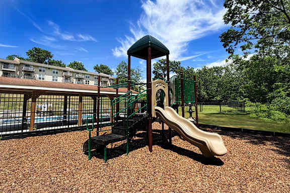 A playground with a slide and a green roofed structure.