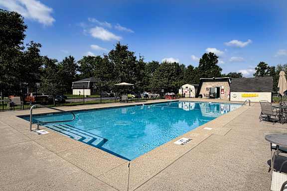 A large outdoor swimming pool with a blue tiled edge and a white line in the middle.