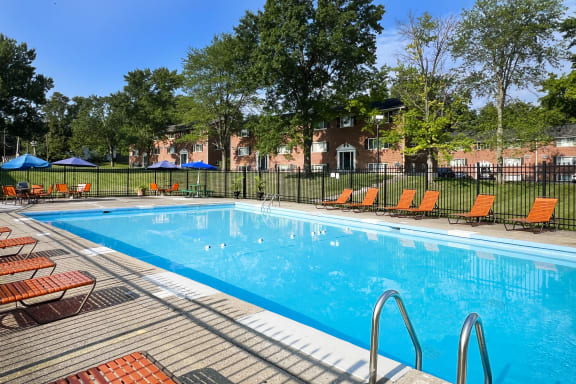 a swimming pool with orange chairs and a fence around it at Sharondale Woods Apartments, Cincinnati, OH, 45241