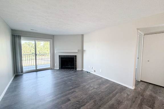 A room with a fireplace and sliding glass doors.