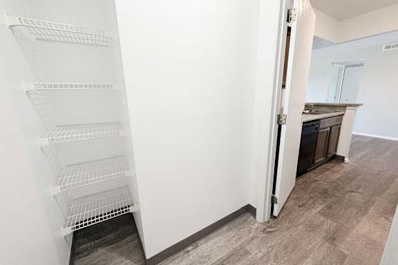 A white shelving unit in a room with a grey floor.