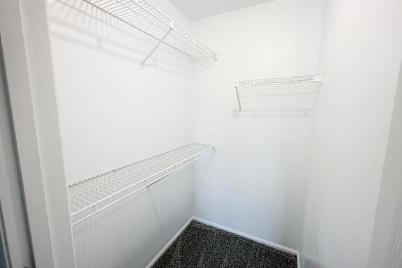 A white empty pantry with a black floor.