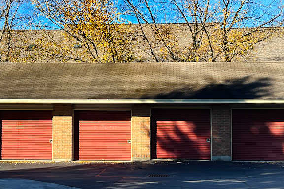A building with red garage doors and a grey roof.