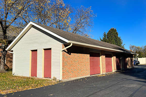 A garage with a grey roof and red doors.