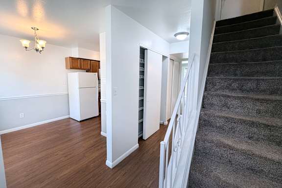 A staircase with a carpeted runner leads up to a second floor.