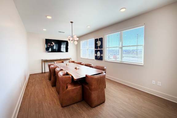 Dining room with wood table and brown upholstered chairs at The Meridian on 32 Apartments, Ohio