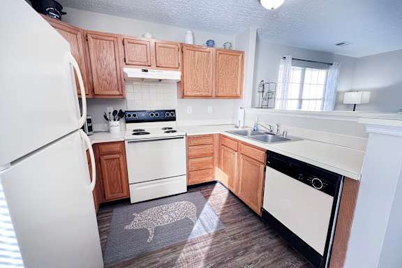 A kitchen with wooden cabinets and a white fridge.