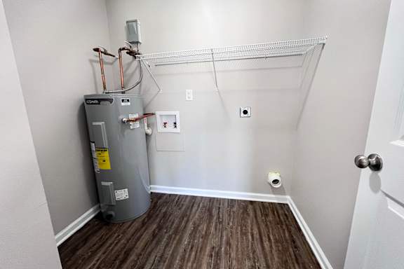 A room with a furnace and a wood floor.