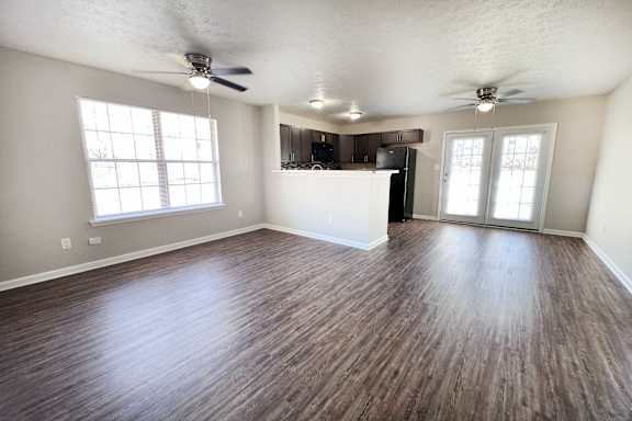 A room with wooden flooring and a ceiling fan.