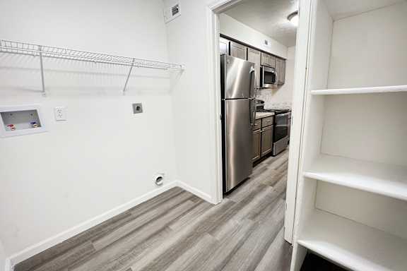 an empty kitchen with a stainless steel refrigerator and