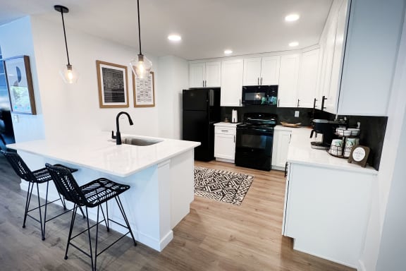 a kitchen with white cabinets and black appliances at Indian Lookout Apartments, Cincinnati, Ohio