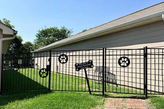 A black metal fence with a mailbox and a wheel design on it.