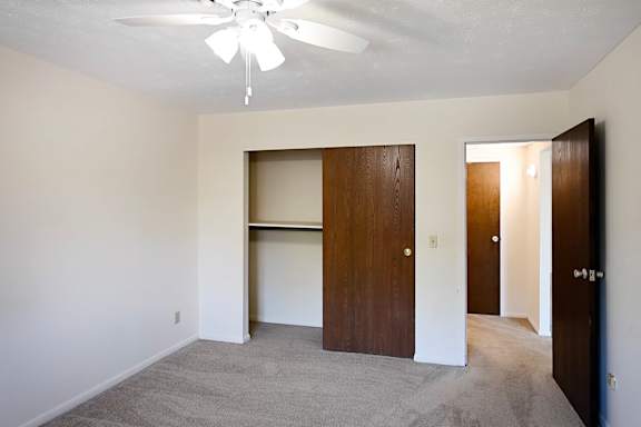 A room with a ceiling fan and two doors.