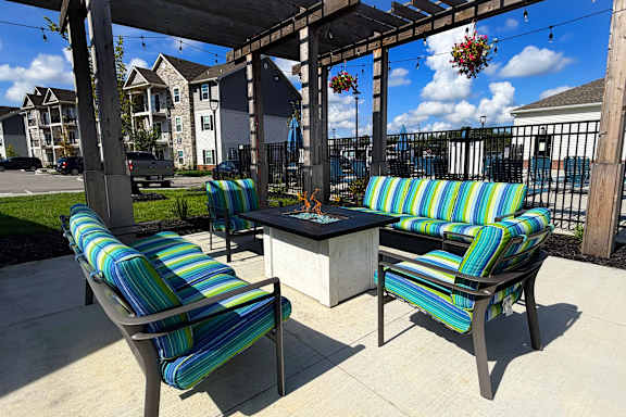 Two striped chairs and a table are on a patio.