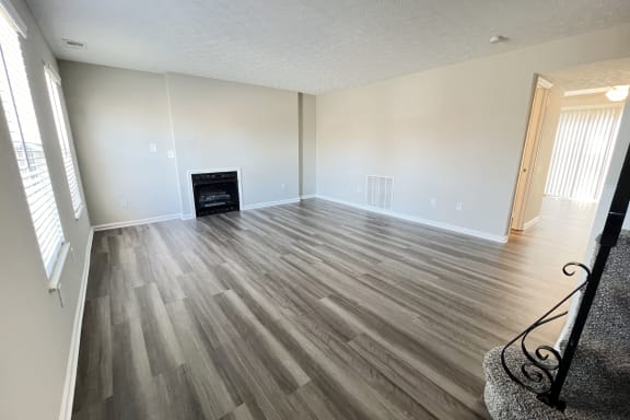 an empty living room with wood flooring and a fireplaceat Revere Village Apartments, Centerville, OH, 45458