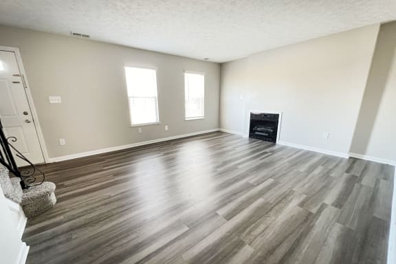 an empty living room with wooden floors and a fireplaceat Revere Village Apartments, Ohio, 45458
