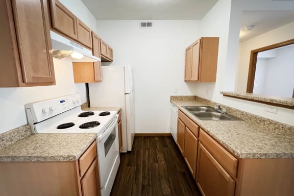 a kitchen with white appliances and granite counter tops and wooden cabinets  at Brookfield Village Apartments, Ohio, 43123
