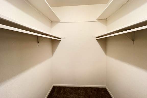Empty white hallway with shelves on the side.