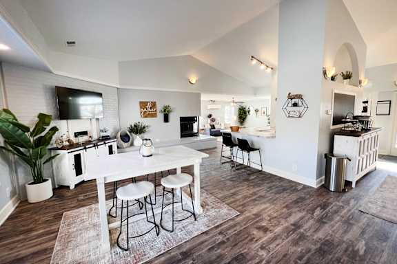 A kitchen with a white table and chairs.