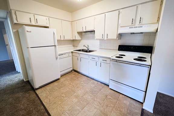 A kitchen with white appliances and cabinets.