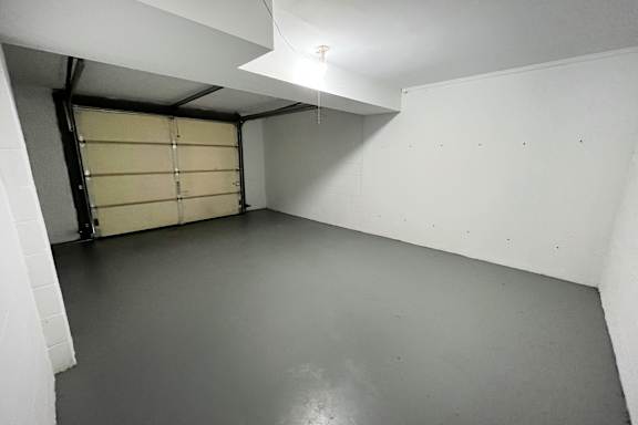 A white room with a roller shutter door.