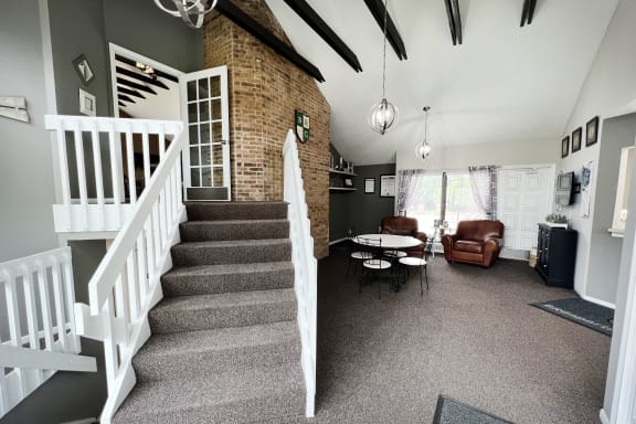 a staircase in a house with a brick wall and a white railing  at Hunter's Creek Apartments, Cincinnati, OH