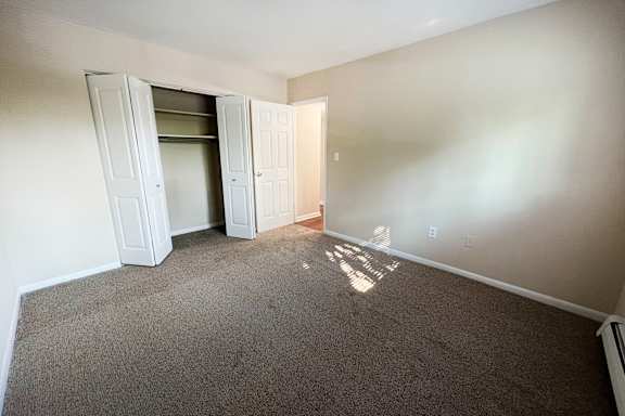 A room with a carpeted floor and a white door.