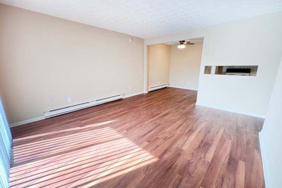 A room with wooden flooring and a ceiling fan.