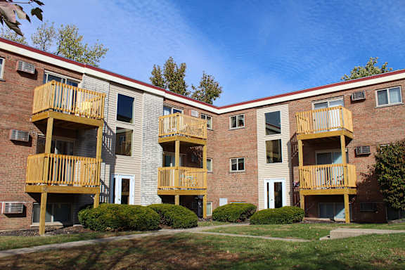 Apartment building with yellow balconies and a red roof.