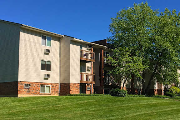 A building with a green lawn in front.