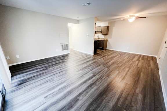 A room with wooden flooring and a ceiling fan.