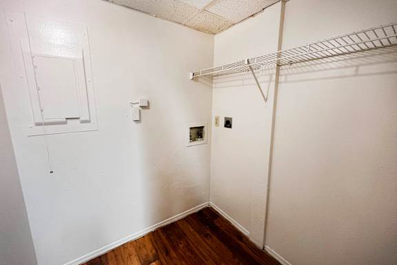 A white closet with a shelf and a door.