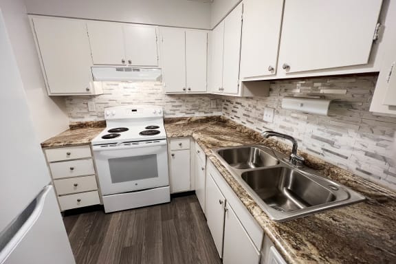 a kitchen with white appliances with granite counter tops at Oakwood Apartments, Florence, KY, 41042