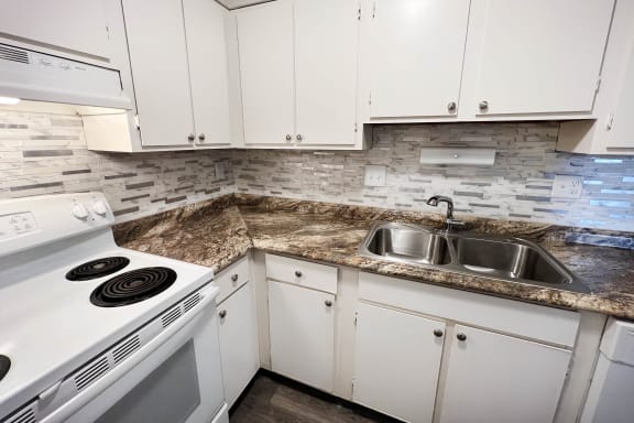 a kitchen with white appliances and granite counter tops at Oakwood Apartments, Florence