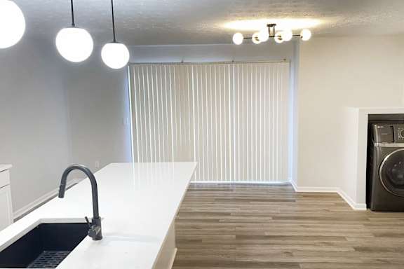 A modern kitchen with a white countertop and a black dishwasher.