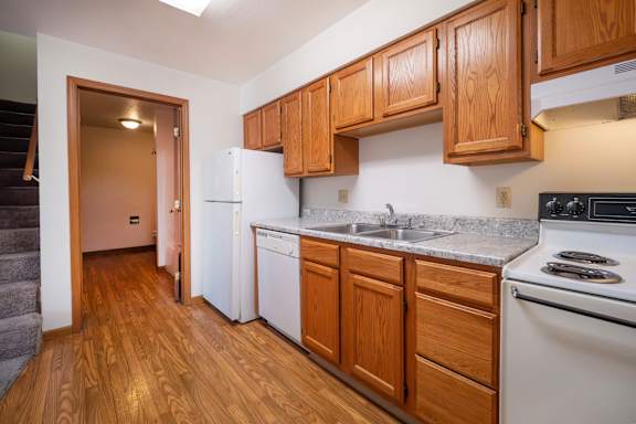 A kitchen with wooden cabinets and a white refrigerator.