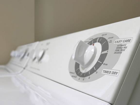 A white washing machine with a control panel that includes a dial for "Easy Care" and a switch for "Timed Dry.".
