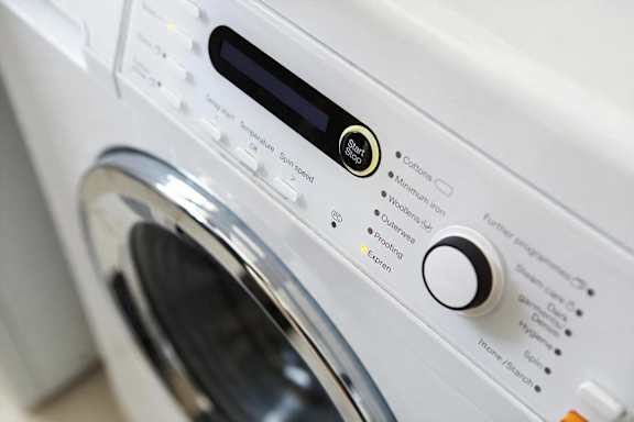 A close up of a washing machine control panel with various settings.