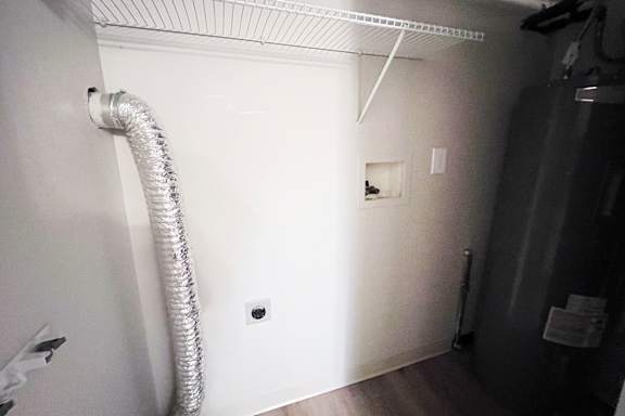 A white wall with a silver duct pipe coming out of it.