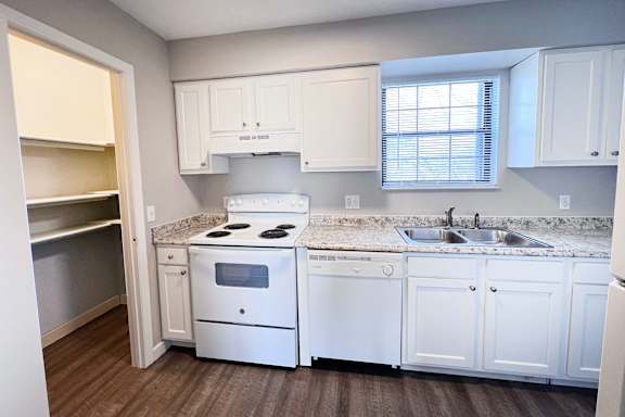 A kitchen with white cabinets and a granite countertop.