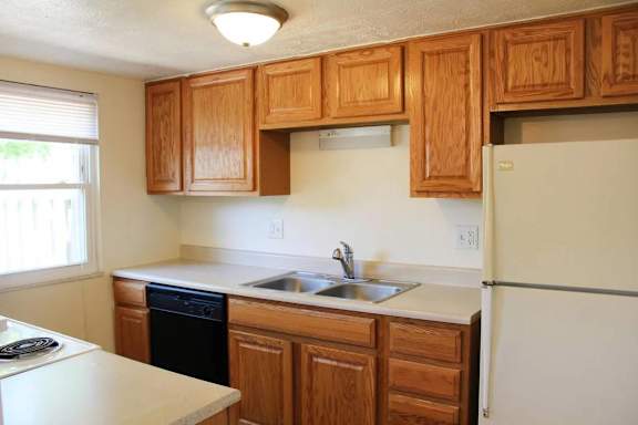 A kitchen with wooden cabinets and a white refrigerator.