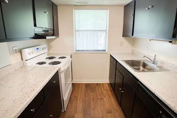 A kitchen with black cabinets and a white countertop.
