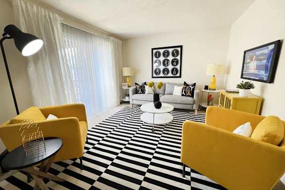 A living room with yellow chairs and a black and white checkered floor.