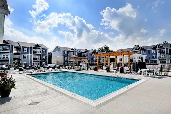 Swimming pool with sundeck chairs and wooden pergola at The Meridian on 32 Apartments, Ohio