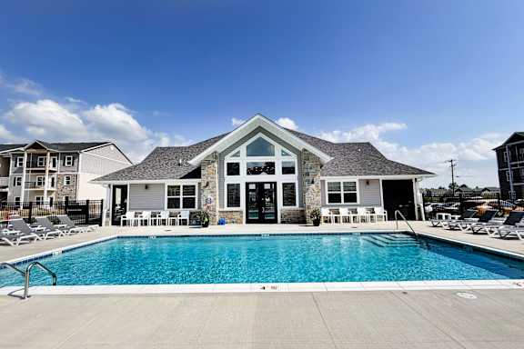 Pool area with clubhouse and sundeck loungers at The Meridian on 32 Apartments, Batavia