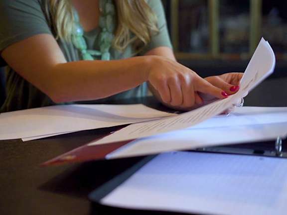A person is cutting a piece of paper with a pair of scissors.