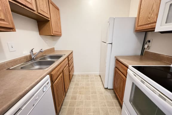 a kitchen with white appliances and wooden cabinetsat Revere Village Apartments, Ohio, 45458